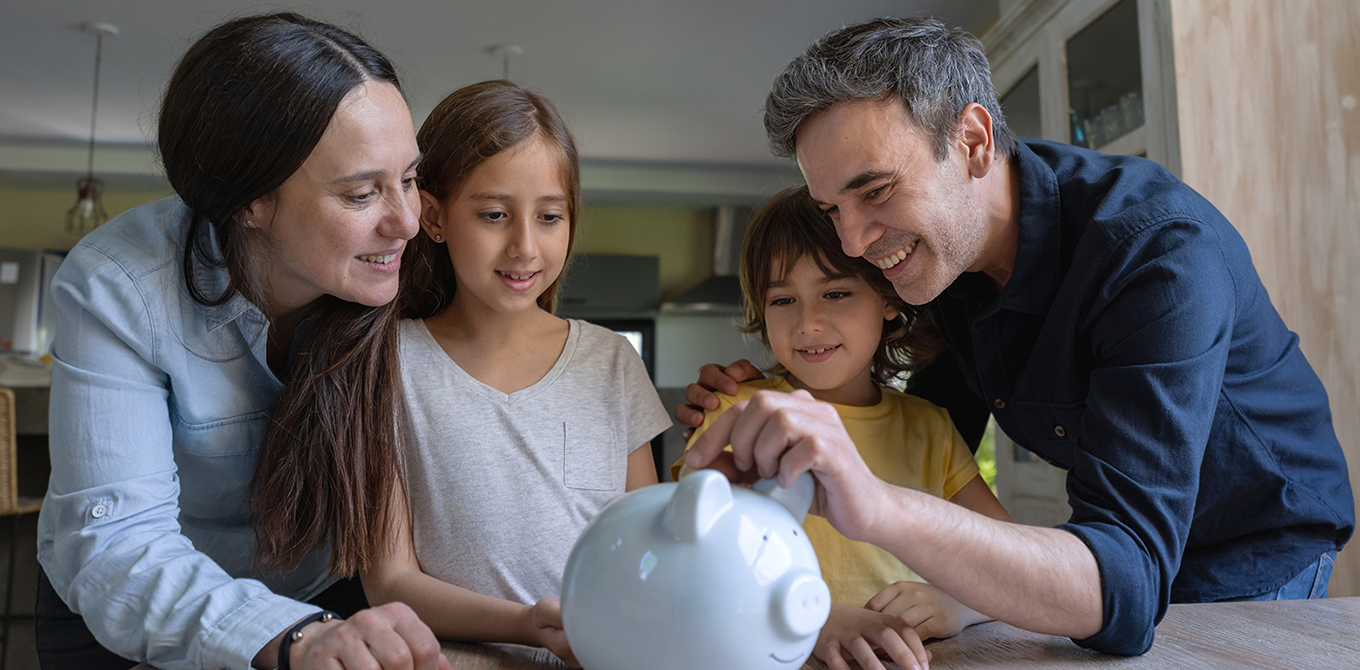 Parents teaching their kids to save money in a piggy bank stock.